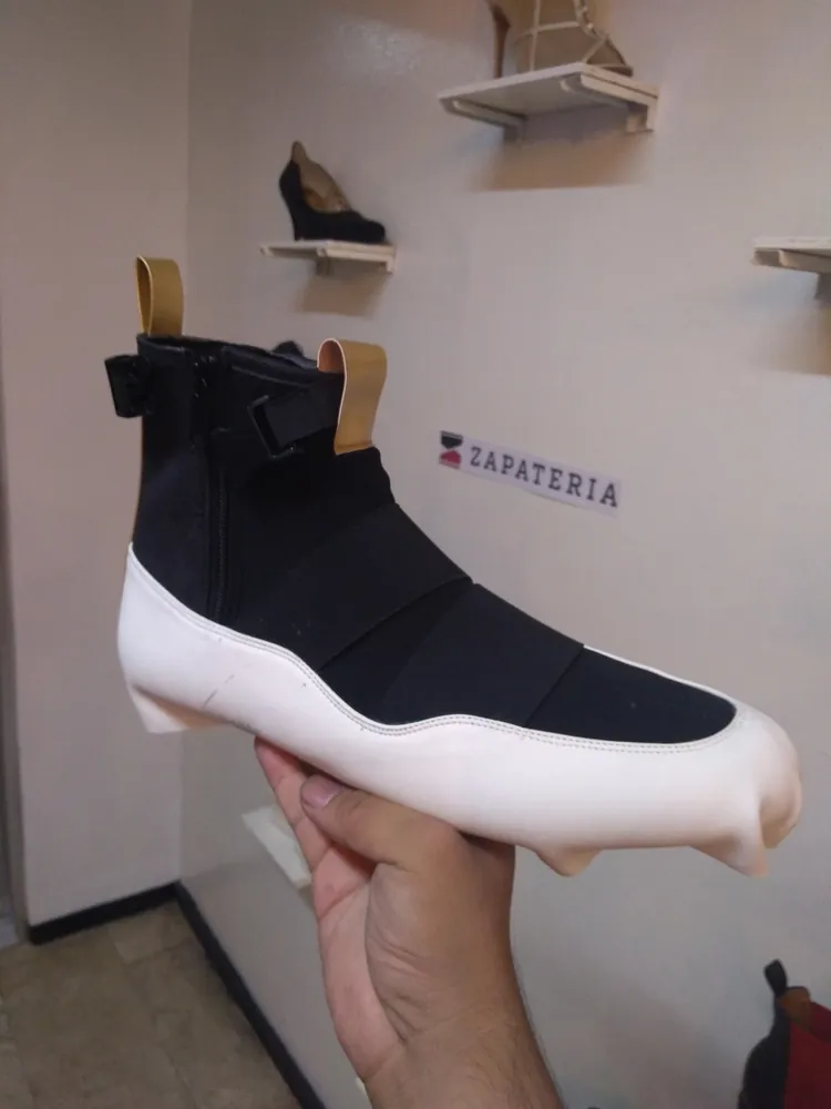 First prototype held in hand, black neoprene upper on a white cupsole